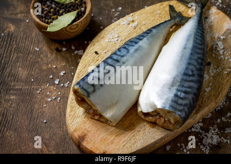 Pesce fresco. Ingredienti per la cottura del pesce per la marinata. Sgombri con sale e spezie su di un tavolo di legno. Copia dello spazio. Foto Stock