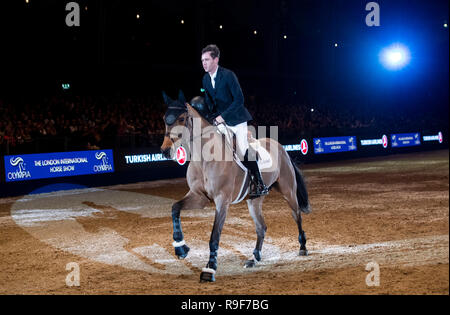 Gran Bretagna Scott insolente cavalca il suo cavallo Ursula fuori dell'arena per l'ultima volta prima del suo ritiro dalle competizioni durante il giorno sette del London International Horse Show a Olympia di Londra. Foto Stock