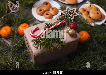 Tradizionale svedese ciambelle di zafferano, noto anche come lussekatter lussebullar o. Il giallo panini hanno uvetta e sono sagomate in spirali e confezione regalo xwith Foto Stock