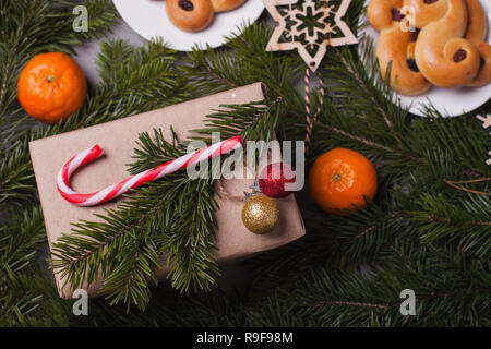 Tradizionale svedese ciambelle di zafferano, noto anche come lussekatter lussebullar o. Il giallo panini hanno uvetta e sono sagomate in spirali e confezione regalo xwith Foto Stock