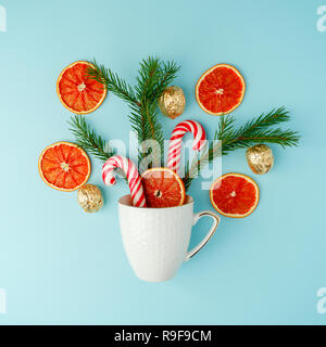 Raccolta di oggetti di Natale in una tazza visto dal di sopra. Vacanza invernale, concetto tradizionale winter dolcezza candy cane su sfondo blu Foto Stock