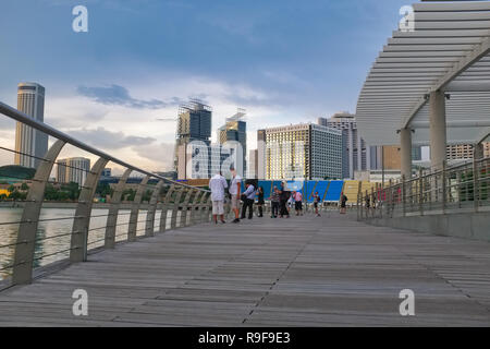 Il lungomare di fronte al ArtScience Museum di Singapore, guardando fuori di Marina Bay; in background diversi hotel di lusso Foto Stock