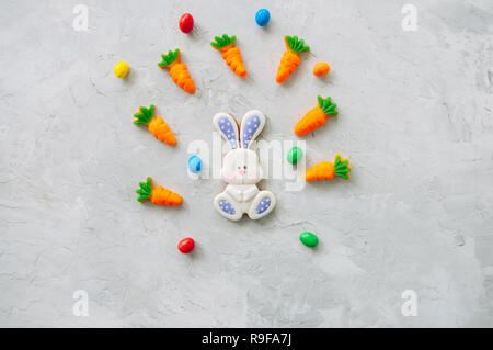 Easter Bunny cookies e carota marmellata da masticare con canditi su una pietra bianca dello sfondo. Vista superiore e spazio di copia. Foto Stock