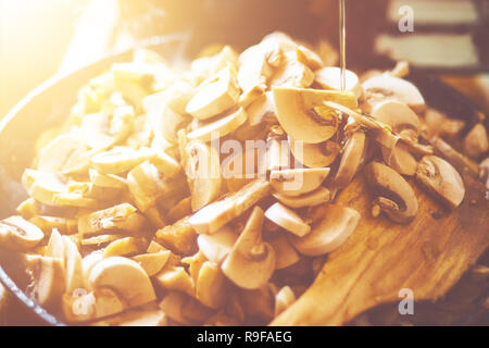 I funghi tritati con pollo grigliato riempito di olio in una padella Foto Stock