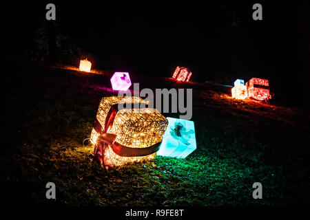 Avvolto illuminato regali di Natale tumbling discesa da una collina sul Palazzo di Blenheim natale luce trail. Dicembre 2018 Foto Stock