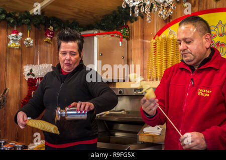 I venditori ambulanti in un fast food stand con vendita di twister gettoni / twisted patatine al mercato di Natale in inverno nella città di Gand, Fiandre, in Belgio Foto Stock