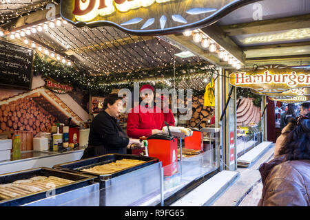 I venditori ambulanti in un fast food stand con vendita di hot dog al mercato di Natale in inverno nella città di Gand, Fiandre, in Belgio Foto Stock