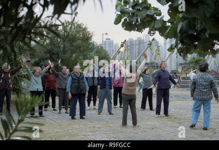 Anni ottanta, Hong Kong, un gruppo di persone anziane signore cinese di mattina facendo esercizi aerobici al di fuori di un'area pavimentata in città. Insieme ad altri fattori, è uno dei motivi per cui la speranza di vita delle donne è la più alta del mondo, a 87,3 anni. Foto Stock