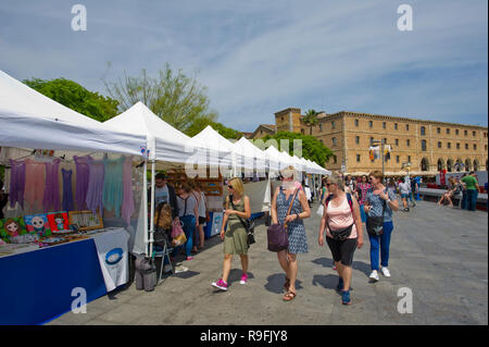 Una fila di bancarelle di vendita di tutti i tipi di arte e artigianato lungo la passeggiata vicino al Museo di Storia della Catalogna a Barcellona, Spagna Foto Stock