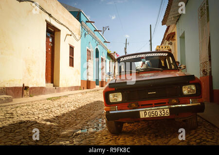 Un classico vintage russo rosso Lada in taxi parcheggiato su strade acciottolate del Trinidad, Cuba. Foto Stock