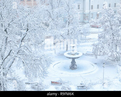 Fontana a Ivan Franko Square a Kiev in Ucraina in inverno coperti di neve. Rami di alberi piegati sotto il peso della neve. Foto Stock