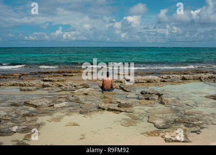 L uomo dal di dietro a meditare sulla spiaggia di Johnny Cay (isoletta); vicino a San Andrés isola, Colombia. Stile di vita / concetto di viaggio, RF. Ott 2018 Foto Stock