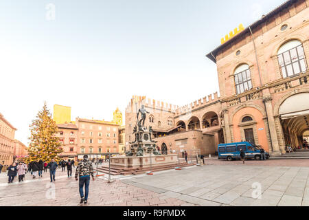 BOLOGNA, Italia - 10 dicembre 2018: le luci di Natale sono illuminanti gente camminare vicino alla fontana del Nettuno, attrazione principale nel centro storico di Foto Stock