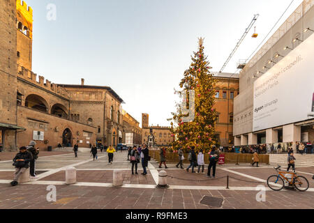 BOLOGNA, Italia - 10 dicembre 2018: le luci di Natale sono illuminanti gente camminare vicino alla fontana del Nettuno, attrazione principale nel centro storico di Foto Stock