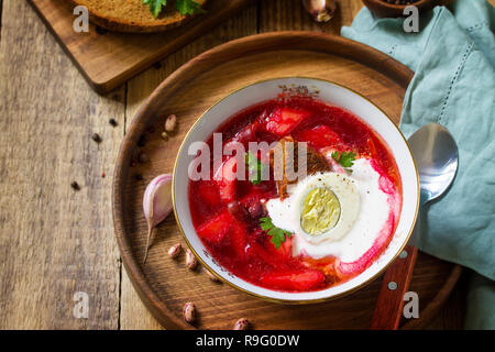 Tradizionale Russo Ucraino borscht. Borsch, zuppa di barbabietole con panna acida in un recipiente da cucina tavolo in legno. Copia dello spazio. Foto Stock