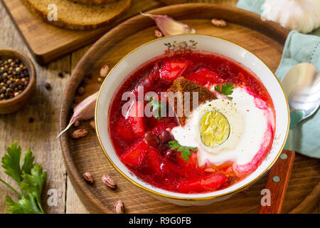 Tradizionale Russo Ucraino borscht. Borsch, zuppa di barbabietole con panna acida in un recipiente da cucina tavolo in legno. Foto Stock