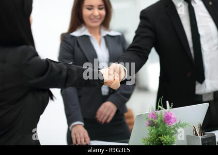 Due imprenditrici stringono le mani su una scrivania come loro di chiudere una trattativa Foto Stock