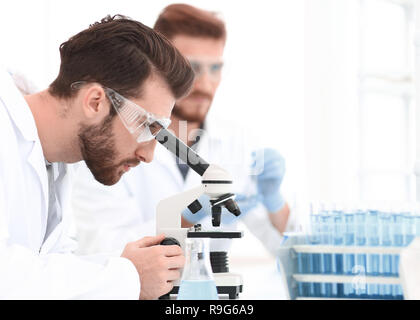 Biologo esplora la sostanza sotto il microscopio Foto Stock