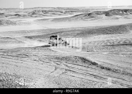 Gara di deserto di sabbia. Auto suv supera le dune di sabbia di ostacoli. Concorrenza racing sfida deserto. Unità auto offroad con nuvole di polvere. Offroad racing del veicolo con degli ostacoli nel deserto. Foto Stock