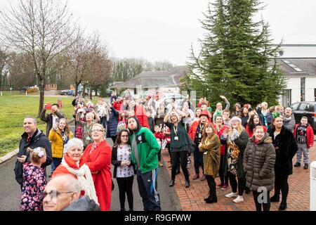 Cardiff, Galles, UK. 24 dicembre, 2018. Sully, Wales, Regno Unito, 24 dicembre 2018. Una folla attende per Babbo Natale a terra a ricovero per bambini Ty Hafan alla vigilia di Natale con l aiuto del Galles Air Ambulance. Credito: Mark Hawkins/Alamy Live News Foto Stock