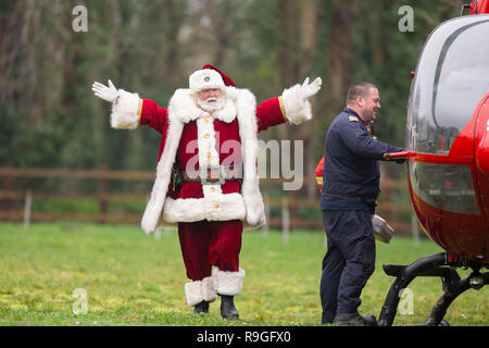 Cardiff, Galles, UK. 24 dicembre, 2018. Sully, Wales, Regno Unito, 24 dicembre 2018. Babbo Natale saluta la folla a ricovero per bambini Ty Hafan alla vigilia di Natale dopo le operazioni di sbarco con l aiuto del Galles Air Ambulance. Credito: Mark Hawkins/Alamy Live News Foto Stock