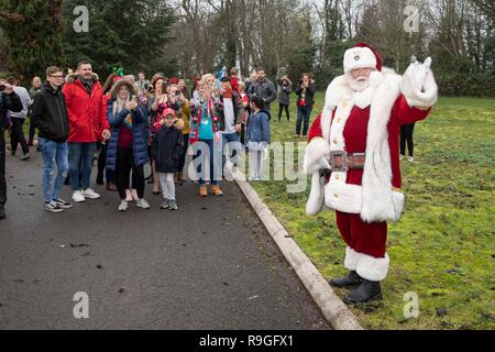 Cardiff, Galles, UK. 24 dicembre, 2018. Sully, Wales, Regno Unito, 24 dicembre 2018. Babbo Natale saluta la folla a ricovero per bambini Ty Hafan alla vigilia di Natale dopo le operazioni di sbarco con l aiuto del Galles Air Ambulance. Credito: Mark Hawkins/Alamy Live News Foto Stock