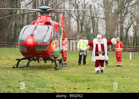 Cardiff, Galles, UK. 24 dicembre, 2018. Sully, Wales, Regno Unito, 24 dicembre 2018. Babbo Natale saluta la folla a ricovero per bambini Ty Hafan alla vigilia di Natale dopo le operazioni di sbarco con l aiuto del Galles Air Ambulance. Credito: Mark Hawkins/Alamy Live News Foto Stock