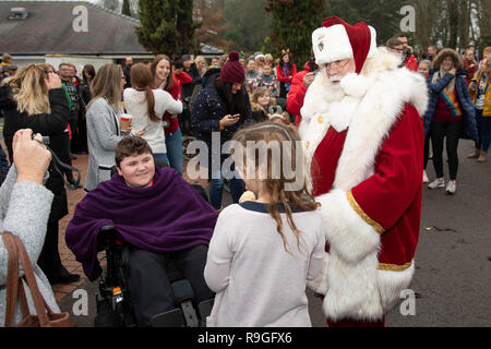 Cardiff, Galles, UK. 24 dicembre, 2018. Sully, Wales, Regno Unito, 24 dicembre 2018. Babbo Natale saluta la folla a ricovero per bambini Ty Hafan alla vigilia di Natale dopo le operazioni di sbarco con l aiuto del Galles Air Ambulance. Credito: Mark Hawkins/Alamy Live News Foto Stock