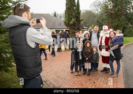 Cardiff, Galles, UK. 24 dicembre, 2018. Sully, Wales, Regno Unito, 24 dicembre 2018. Babbo Natale in posa per una fotografia con il Barnet famiglia dopo lo sbarco a ricovero per bambini Ty Hafan alla vigilia di Natale con l aiuto del Galles Air Ambulance. Credito: Mark Hawkins/Alamy Live News Foto Stock