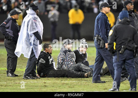 Oakland, CA. 24 dicembre, 2018. Le ventole che espugnato il campo sono stati ammanettati e allineati dopo la NFL partita di calcio tra la Denver Broncos e Oakland Raiders a Oakland Alameda Coliseum di Oakland, CA. Chris Brown/CSM/Alamy Live News Foto Stock