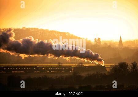 Peterborough, Regno Unito. 24 dicembre, 2018. La Vigilia di Natale Tornado treni a vapore sul Nene Valley Railway poteri che modo attraverso Nene Park appena prima del tramonto in Peterborough, CAMBRIDGESHIRE, il 24 dicembre 2018. Credito: Paolo Marriott/Alamy Live News Foto Stock