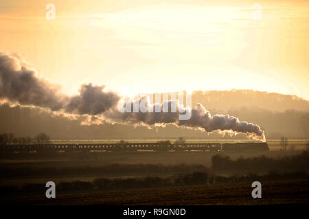 Peterborough, Regno Unito. 24 dicembre, 2018. La Vigilia di Natale Tornado treni a vapore sul Nene Valley Railway poteri che modo attraverso Nene Park appena prima del tramonto in Peterborough, CAMBRIDGESHIRE, il 24 dicembre 2018. Credito: Paolo Marriott/Alamy Live News Foto Stock