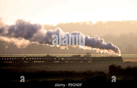Peterborough, Regno Unito. 24 dicembre, 2018. La Vigilia di Natale Tornado treni a vapore sul Nene Valley Railway poteri che modo attraverso Nene Park appena prima del tramonto in Peterborough, CAMBRIDGESHIRE, il 24 dicembre 2018. Credito: Paolo Marriott/Alamy Live News Foto Stock