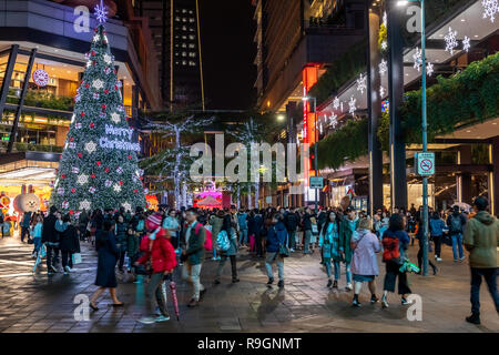 Taipei, Taiwan, 24 dicembre, 2018: Taipei residenti passeggiata attraverso la città di Xinyi quartiere degli affari in una piovosa vigilia di Natale. Credito: Perry Svensson/Alamy Live News Foto Stock