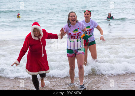 Boscombe, Bournemouth, Dorset, Regno Unito. Giorno di Natale 25 dicembre 2018. Volontari coraggiosi si tuffano nel freddo mare agitoso per una nuotata, per l'annuale immersione di Natale bianca di beneficenza, vestiti con costumi di fantasia e raccogliendo denaro per Macmillan che si prende cura a Christchurch, una Specialist Palliative Care Unit per i pazienti nella comunità locale. Centinaia di persone partecipano all'evento che è diventato una tradizione popolare per molti prima del pranzo di Natale. Credit: Carolyn Jenkins/Alamy Live News Foto Stock