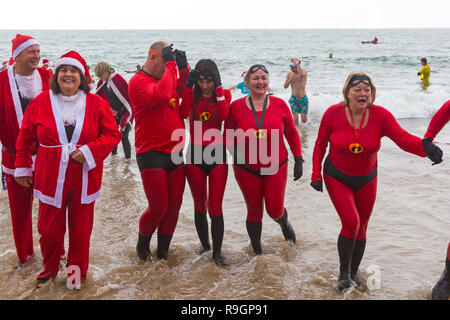 Boscombe, Bournemouth, Dorset, Regno Unito. Giorno di Natale 25 dicembre 2018. Volontari coraggiosi si tuffano nel freddo mare agitoso per una nuotata, per l'annuale immersione di Natale bianca di beneficenza, vestiti con costumi di fantasia e raccogliendo denaro per Macmillan che si prende cura a Christchurch, una Specialist Palliative Care Unit per i pazienti nella comunità locale. Centinaia di persone partecipano all'evento che è diventato una tradizione popolare per molti prima del pranzo di Natale. Credit: Carolyn Jenkins/Alamy Live News Foto Stock