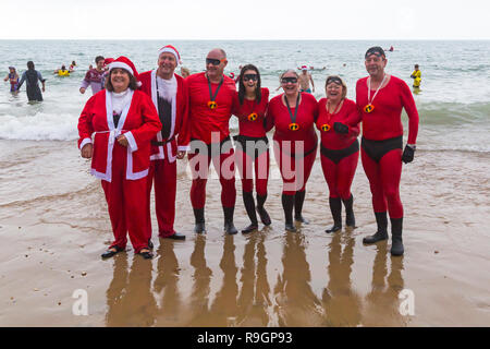 Boscombe, Bournemouth, Dorset, Regno Unito. Giorno di Natale 25 dicembre 2018. Volontari coraggiosi si tuffano nel freddo mare agitoso per una nuotata, per l'annuale immersione di Natale bianca di beneficenza, vestiti con costumi di fantasia e raccogliendo denaro per Macmillan che si prende cura a Christchurch, una Specialist Palliative Care Unit per i pazienti nella comunità locale. Centinaia di persone partecipano all'evento che è diventato una tradizione popolare per molti prima del pranzo di Natale. Credit: Carolyn Jenkins/Alamy Live News Foto Stock
