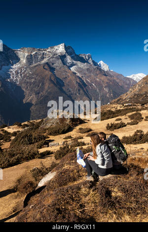 Np893 Nepal, Namche Bazar, giovane guardando la mappa di fronte Kongde Ri, sul sentiero fino a Namche Bazaar airfield Foto Stock