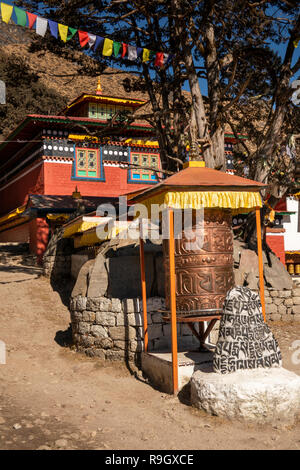 Il Nepal, il Campo Base Everest Trek, Khumjung, tradizionale ruota di preghiera e mani la pietra fuori dal villaggio gompa Foto Stock
