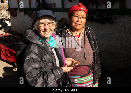 Np950 Nepal, Campo Base Everest Trek, Khumjung village, trekker con donna locale a piccoli souvenir turistici in stallo sulla strada per il villaggio di gompa Foto Stock