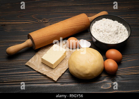 Srotolato e crudi di pasta frolla ricetta impasto su sfondo di legno Foto Stock