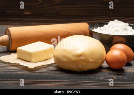 Srotolato e crudi di pasta frolla ricetta impasto su sfondo di legno Foto Stock