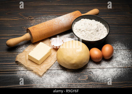 Srotolato e crudi di pasta frolla ricetta impasto su sfondo di legno Foto Stock