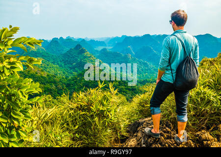 Viaggiatore con Halong Bay punto di vista montagna da Cat Ba Island in Vietnam Foto Stock