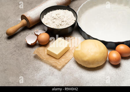 Srotolato e crudi di pasta frolla ricetta impasto su sfondo di calcestruzzo Foto Stock