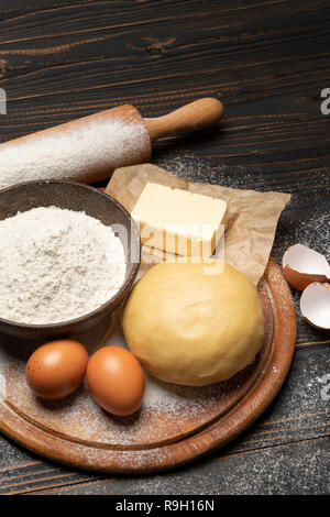 Srotolato e crudi di pasta frolla ricetta impasto su sfondo di legno Foto Stock