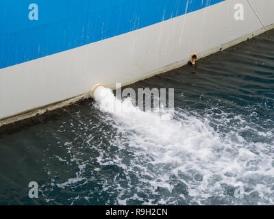 Acqua di sentina pompata fuori del lato di una nave in acqua del porto Foto Stock