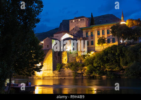 Vista notturna di case lungo il fiume Neretva, Mostar Bosnia ed Erzegovina Foto Stock