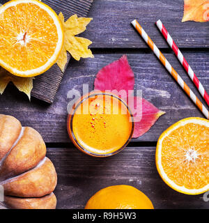 Zucca di fresco e succo di arance su sfondo di legno nella stagione autunnale Foto Stock