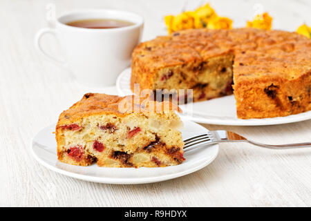 Closeup pezzo di torta casalinga con pera, ciliegie e cioccolato bianco su un tavolo di legno. Messa a fuoco poco profonde. Foto Stock